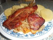 Pečená pikantní uzená krkovice na kysaném zelí, bramborový knedlík Láznička